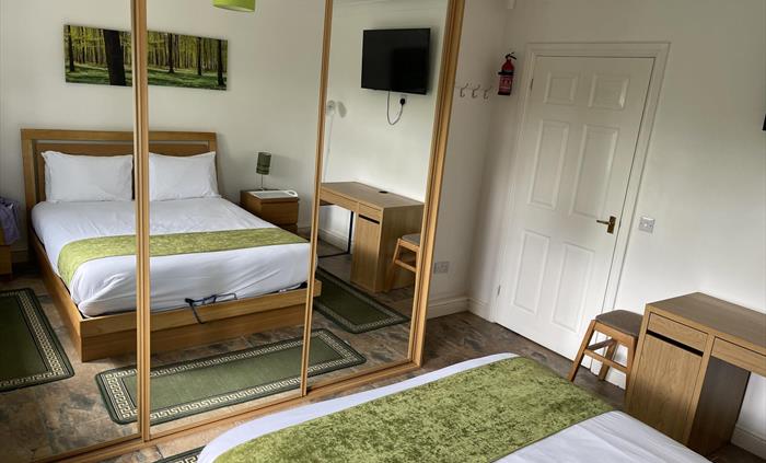 shows UK king size bed, 2 bedside cabinets, writing desk, stool (office or wooden chair available on request), mirror wardrobes and 43" Smart Tv with